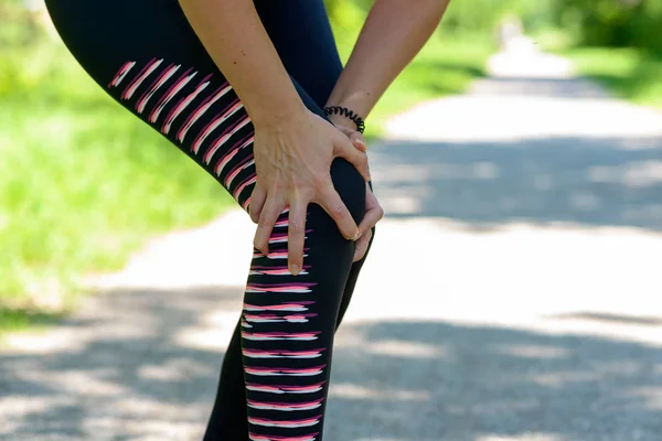 Close Mujer Atlética Sosteniendo Dolorosa Rodilla Lesionada Mientras Hace Ejercicio — Foto de Stock