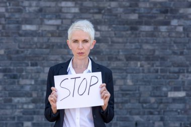 İşkadını yazıt Stop işaretiyle kendini önünde tutuyor