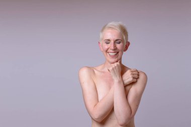 Kapalı gözlerle kameraya gülümseyen güzel çıplak Olgun kadın