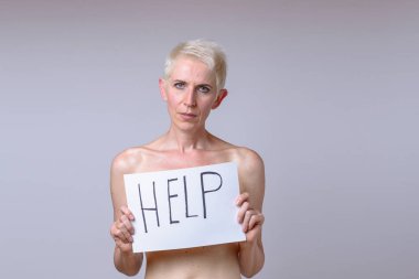 Yardım yazı beyaz sayfaya tutan orta yaşlı kadın