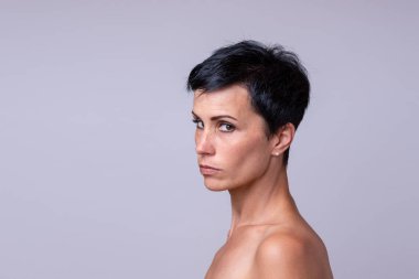 Şüpheli kadın yan Grey kopya alanı ile izole bir ciddi düşünceli ifade ile kameraya arıyor