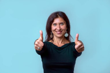 Onay ve gülen bir gülümseme ile başarı jesti Yaşasın hevesli motive orta yaşlı bir kadın
