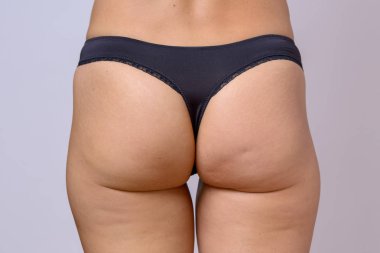 G-string giymiş bir ince uygun kadın trim tonlu arka kırpılmış görünümü kadar yakın bir külot üzerinde gri siyah.