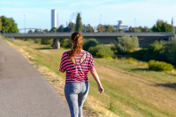 Bakifrån Ung Kvinna Som Bär Sportkläder Promenader Längs Floden — Stockfoto