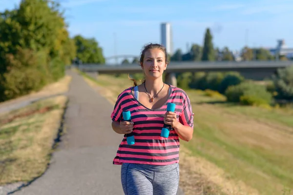 Fit Jonge Vrouw Joggen Bedrijf Kleine Halter Gewichten Haar Handen — Stockfoto