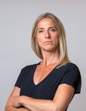 Katlanmış silah kamera ciddi bir yoğun ifade ile gri bakan otoriter kibirli sarışın kadınla