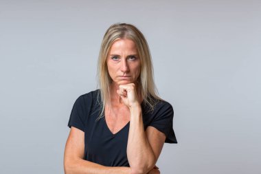 Kararlı odaklı orta yaşlı sarışın kadın kamera onu yumruk yüzünü ve kararlı bir ifade ile dikkatle bakıp