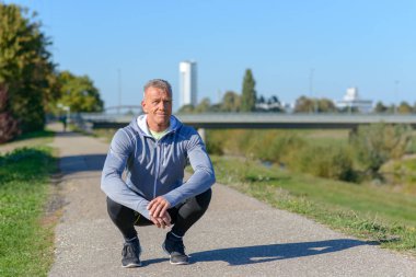 Orta gülümseyen yaşlı bir mola sırasında ağız kavgası içinde oturan runner