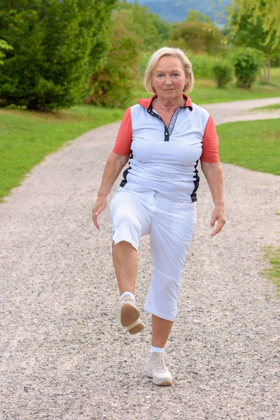 Спортивная Пожилая Женщина Делает Спортивные Упражнения Одной Ногой Воздухе — стоковое фото
