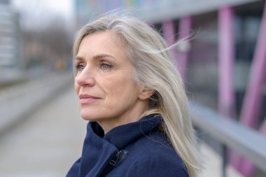 O açık havada bir geçit şehre haliyle dikkatle tarafına düşünceli bir ifade ile arayan ciddi kadın