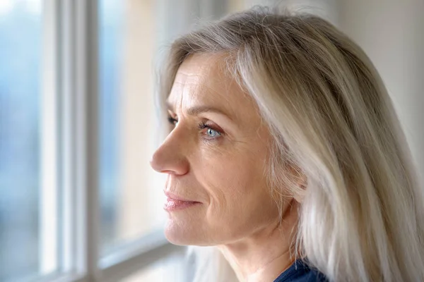 Thoughtful Attractive Mature Blond Woman Blue Eyes Looking Out Window — Stock Photo, Image