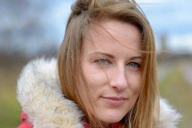 Düşünceli ciddi genç kadın ya da öğrenci uzun sarı saçlı bir kürk giyen bir kış günü açık havada ceket ayakta kırsal kesimde kesilmiş