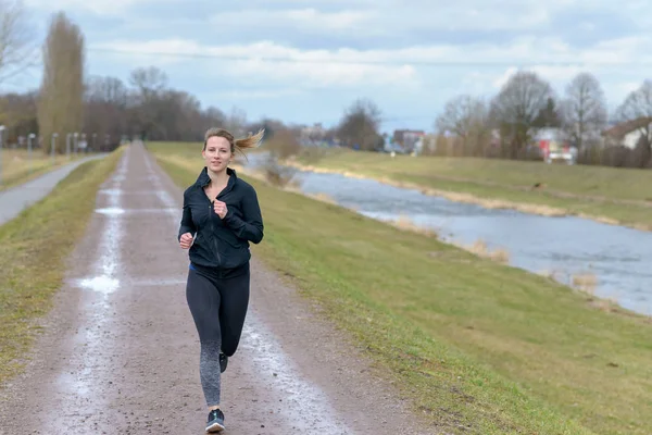 Ajuste Joven Mujer Fuera Corriendo Invierno Acercándose Cámara Largo Camino — Foto de Stock