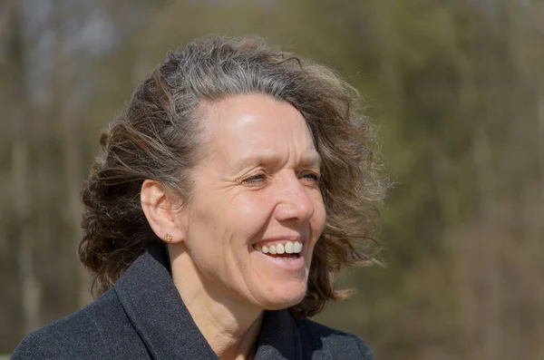 Smiling friendly woman with tousled hair — Stock Photo, Image