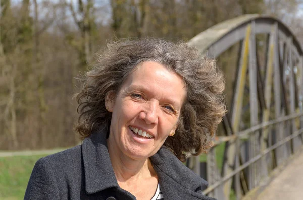 Smiling friendly woman with tousled hair — Stock Photo, Image