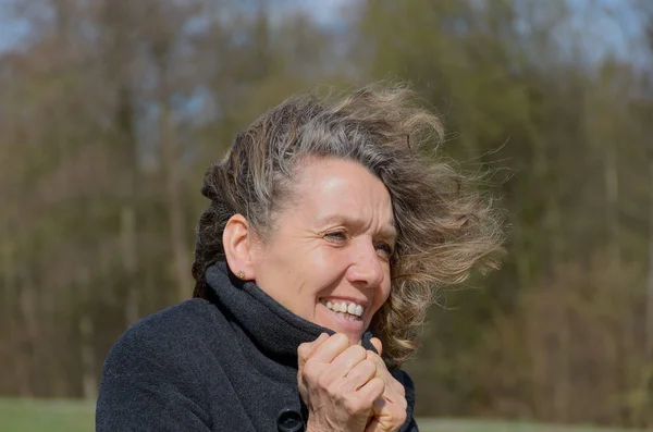 Sorrindo mulher de meia-idade em um dia ventoso — Fotografia de Stock