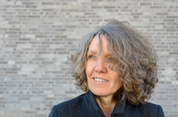 Mature smiling woman with curly tousled hair — Stock Photo, Image