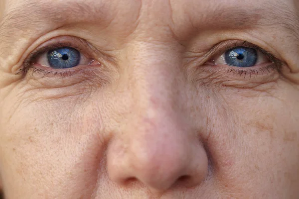 Extremo Rostro recortado de una mujer de mediana edad de ojos azules — Foto de Stock