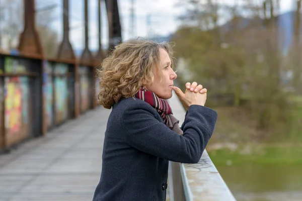 Mujer pensativa mirando desde un puente — Foto de Stock