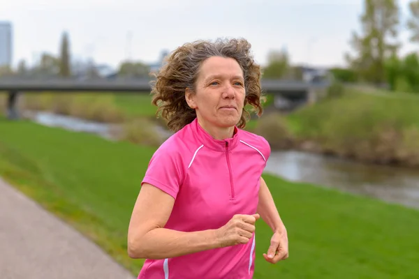 Mujer de mediana edad corriendo en el parque — Foto de Stock