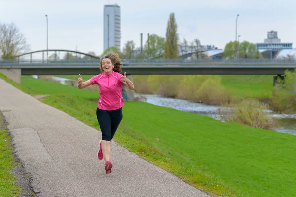 Mujer feliz corredor mostrando pulgares hacia arriba — Foto de Stock