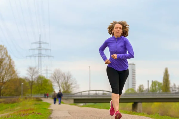 Mujer activa de mediana edad corriendo en invierno — Foto de Stock