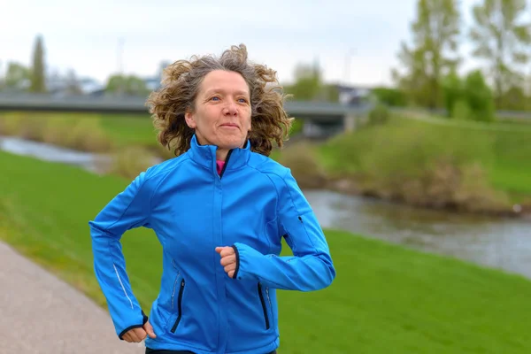Ajuste atlético de mediana edad mujer corriendo — Foto de Stock