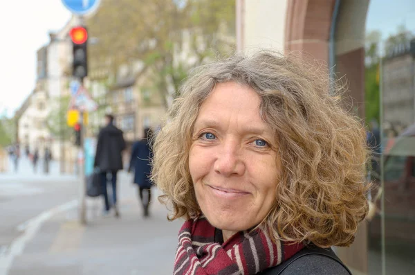 Smiling friendly woman wearing a knitted scarf — Stock Photo, Image