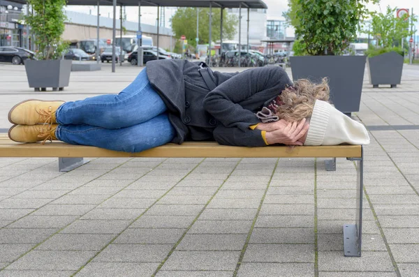 Hemlösa kvinna sova grov på en bänk — Stockfoto