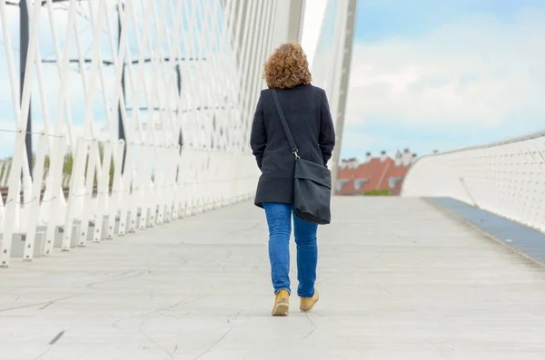 Žena kráčí přes most pro pěší — Stock fotografie
