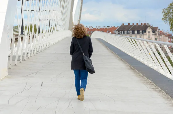 Mujer caminando a través de un puente peatonal — Foto de Stock