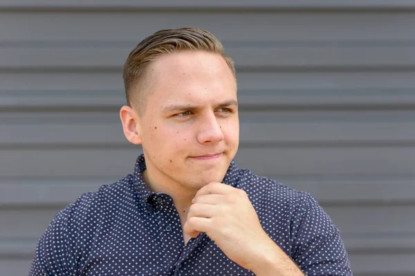 Thoughtful young man with his hand to his chin