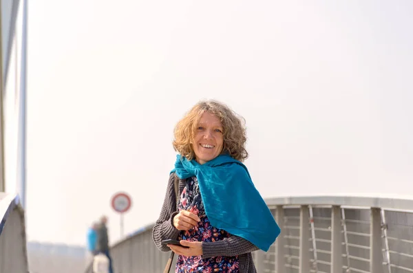 Mujer sonriente en pañuelo azul en el puente — Foto de Stock