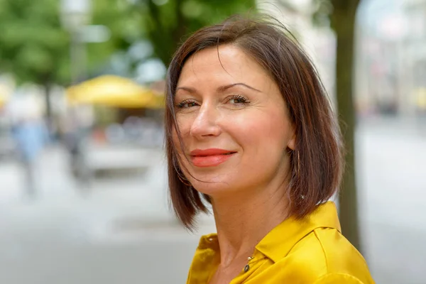 Smiling woman scrutinising the camera — Stock Photo, Image