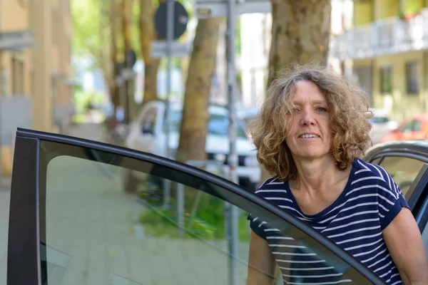 Donna di mezza età che scende da un'auto — Foto Stock