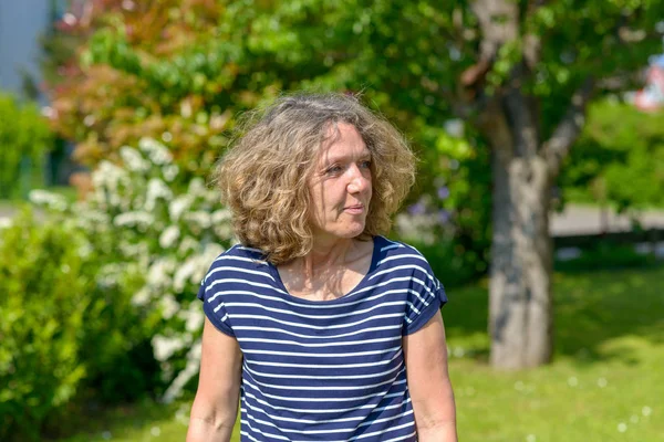Привлекательная женщина средних лет, гуляющая в саду — стоковое фото