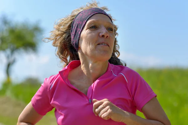 Женщина средних лет бегает трусцой по сельской местности — стоковое фото
