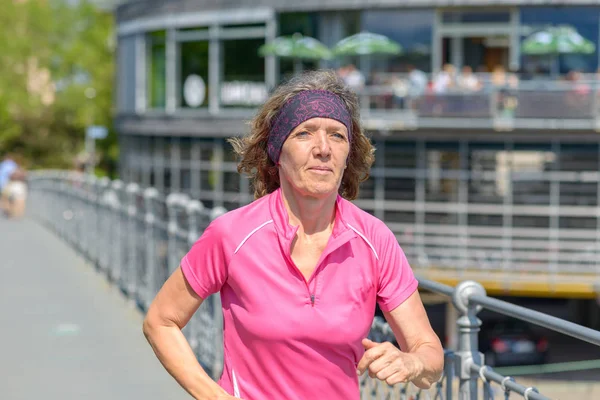 Healthy fit woman jogger running through town