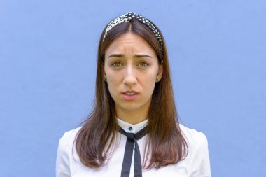 Kameraya kaşlarını çatlayan şaşkın genç kadın