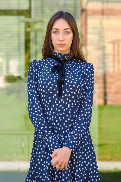 Fashionable serious young woman in polka dot dress
