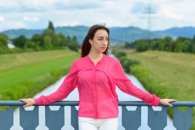 Şık genç kadın düşünme bir köprü üzerinde ayakta