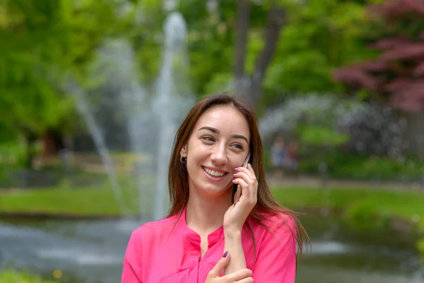 Feliz joven mujer charlando en un teléfono móvil — Foto de Stock