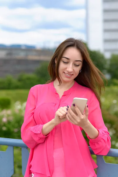 Mujer joven marcando un número en su móvil — Foto de Stock