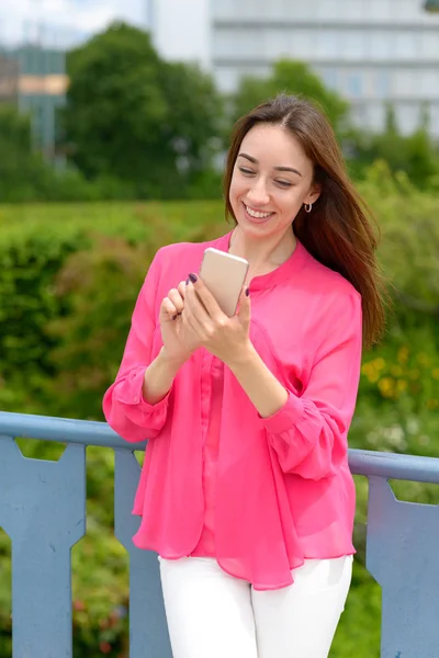 Mladá žena čtení textové zprávy na mobilu — Stock fotografie