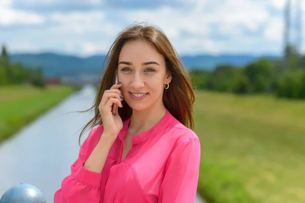 Sonriente mujer atractiva hablando en un móvil — Foto de Stock