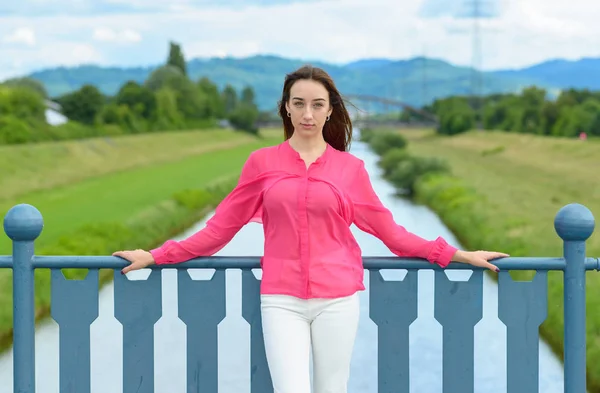 Elegante joven posando sobre un río — Foto de Stock