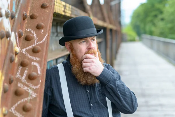 Gondolkodó szakállas férfi a kezét, hogy a szakállát — Stock Fotó