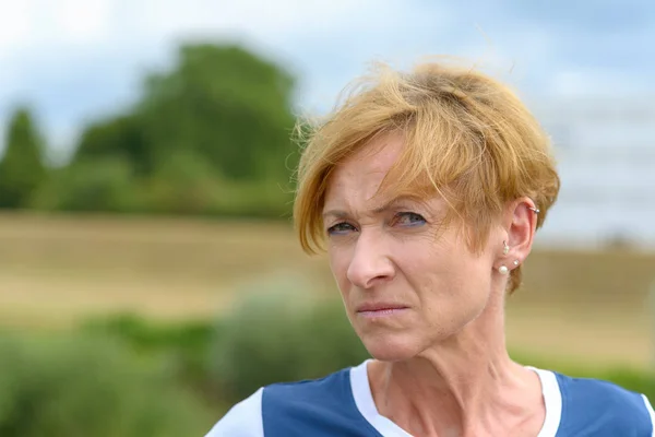 Sceptical woman looking sideways at the camera — Stock Photo, Image