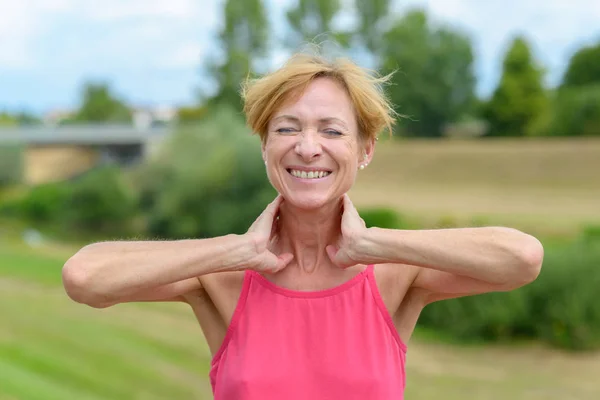 Gelukkige vrouw stretching met handen aan haar nek — Stockfoto