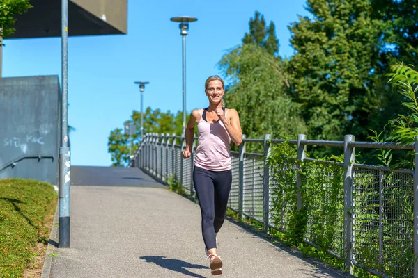 Mujer decidida sonriendo feliz mientras trota — Foto de Stock